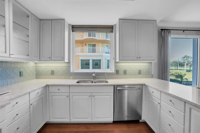 a kitchen with granite countertop white cabinets and stainless steel appliances