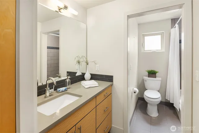 a bathroom with a sink a toilet and a mirror