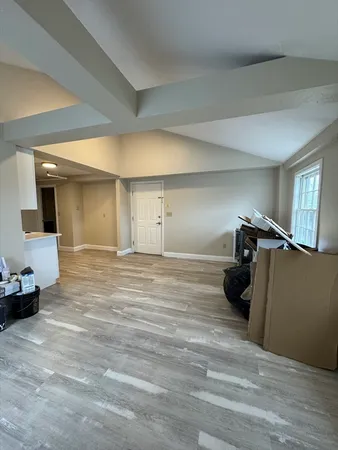 a view of a livingroom with wooden floor and furniture