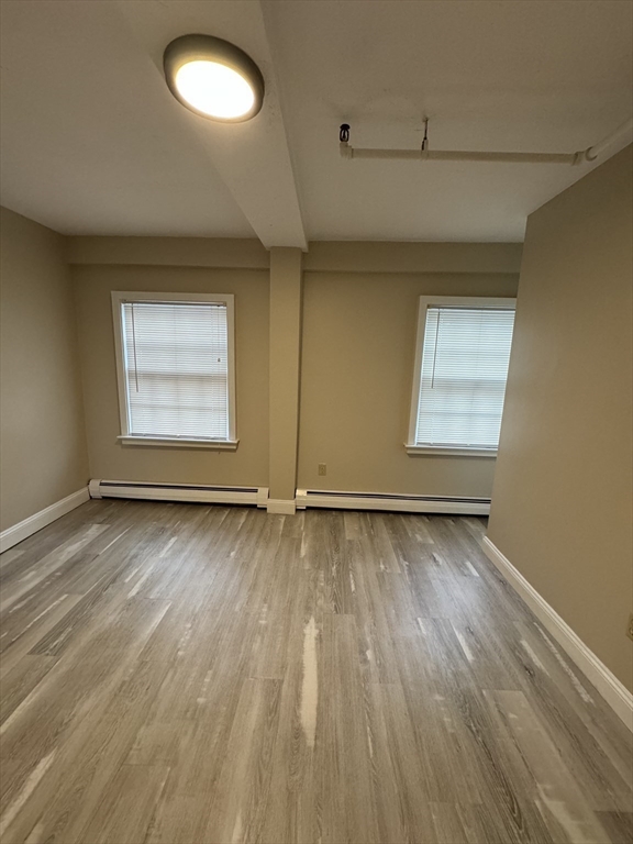52 Washington Street, Unit 9 Marblehead, MA 01945 - Photo 9 of 17 an empty room with wooden floor and windows