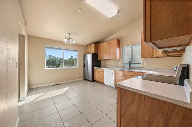 a kitchen with stainless steel appliances granite countertop a sink and a refrigerator
