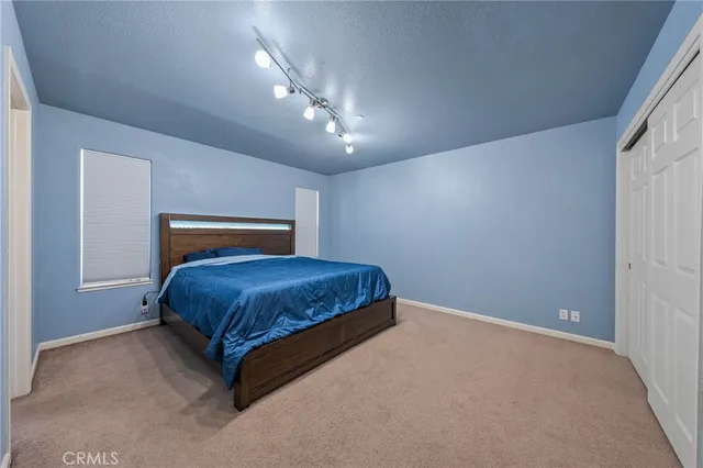 a bedroom with a large bed and a chandelier