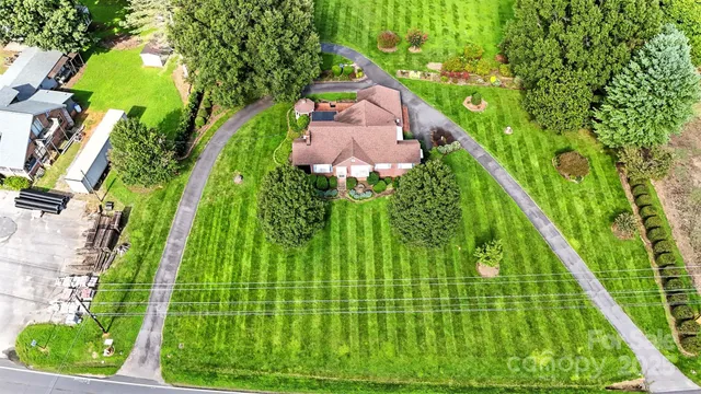 an aerial view of a house with swimming pool garden and mountain view in back