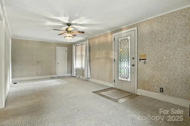 an empty room with windows and ceiling fan