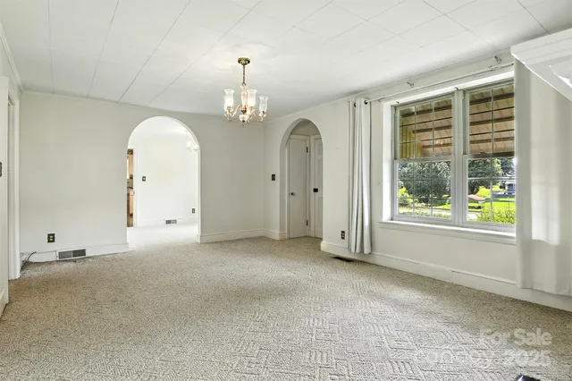 a view of livingroom with furniture chandelier and window