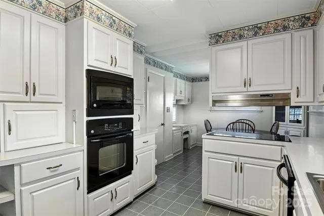 a kitchen with a dining table chairs refrigerator and cabinets