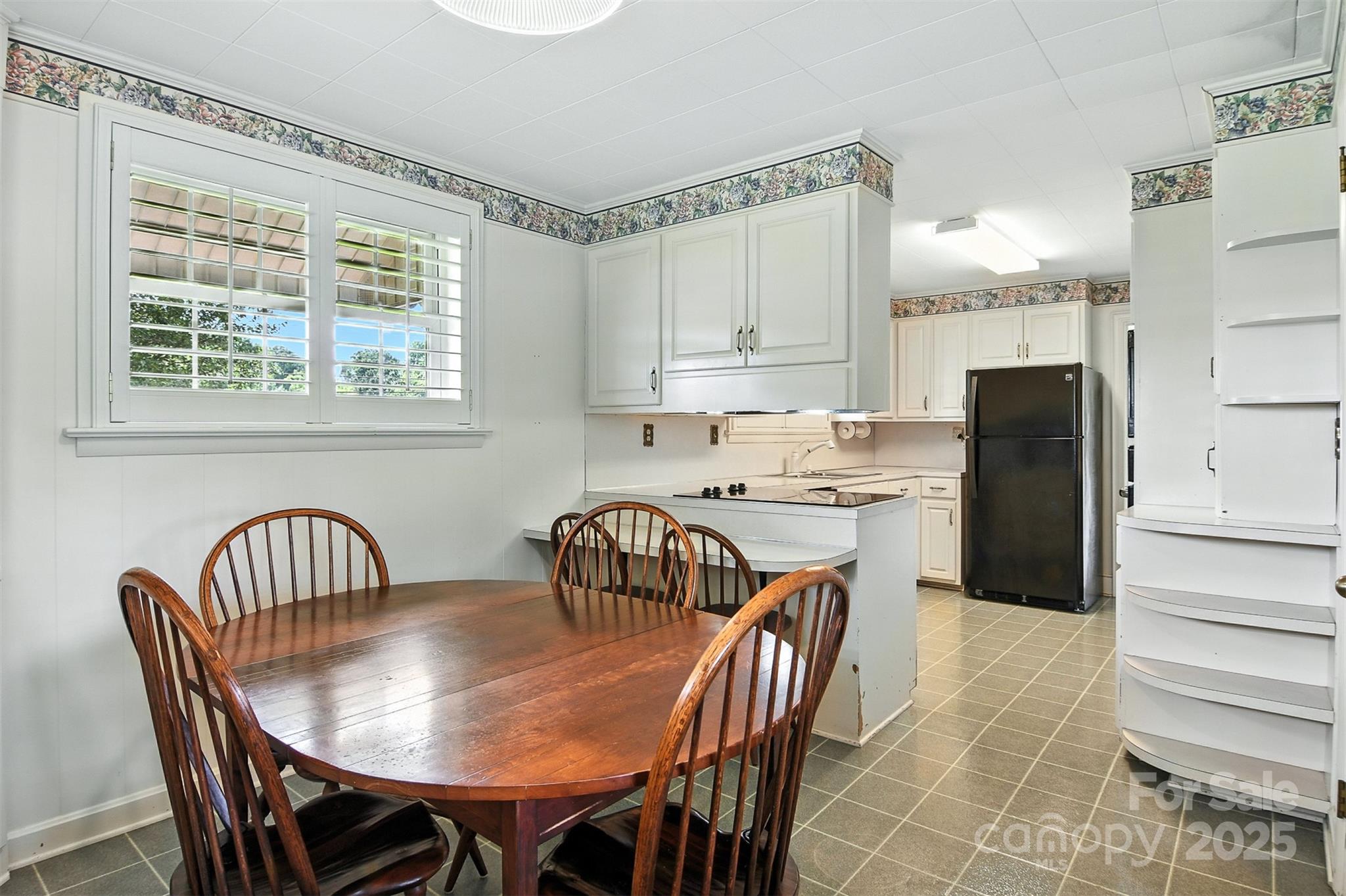 3968 Highway 321 Hudson, NC 28638 - Photo 31 of 47 a kitchen with a dining table chairs refrigerator and cabinets