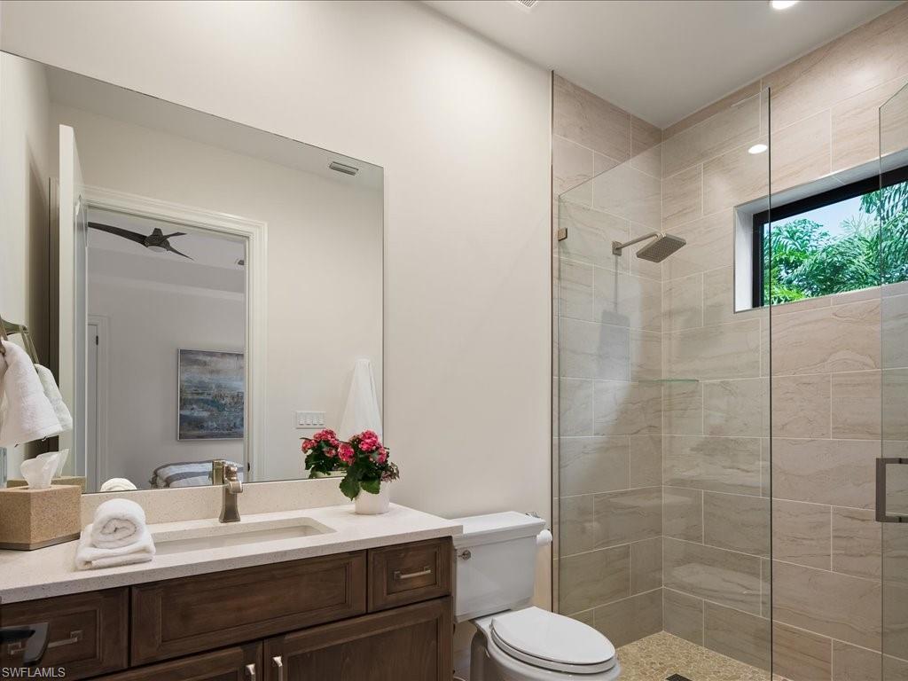 2581 Escada Drive Naples, FL 34109 - Photo 23 of 39 a bathroom with a sink toilet a mirror and shower