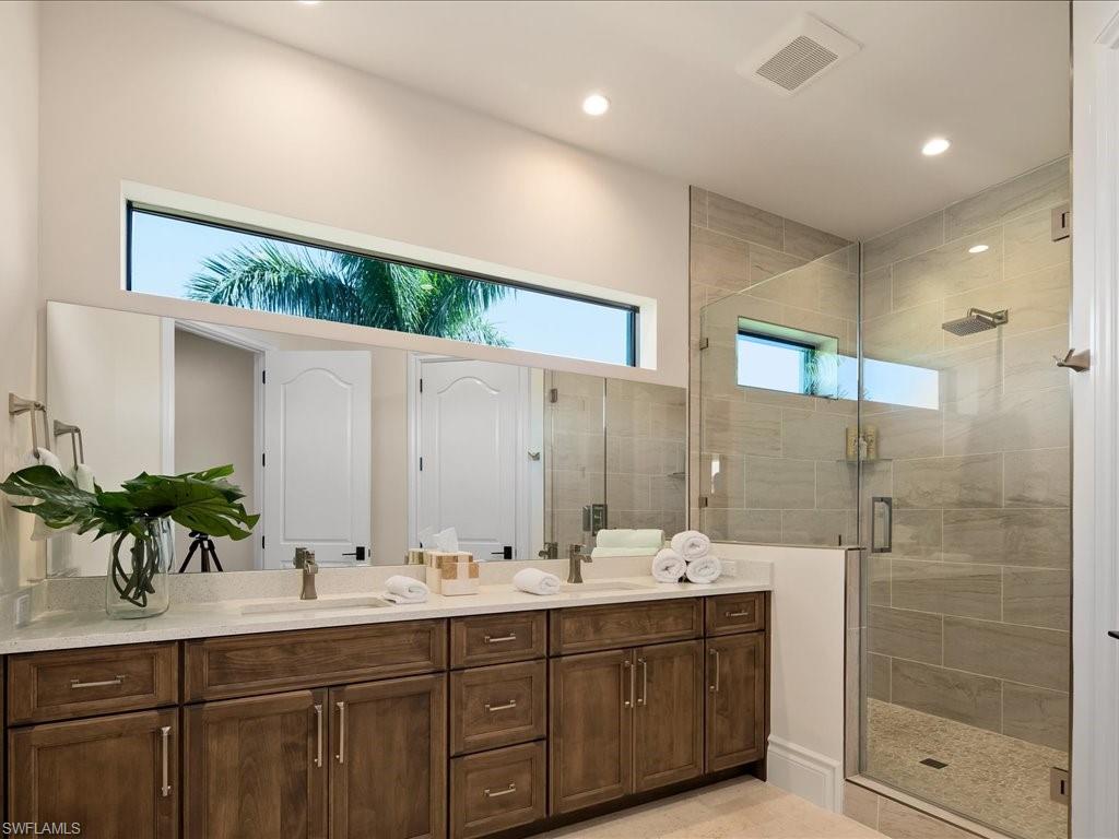 2581 Escada Drive Naples, FL 34109 - Photo 30 of 39 a bathroom with a double vanity sink mirror and shower