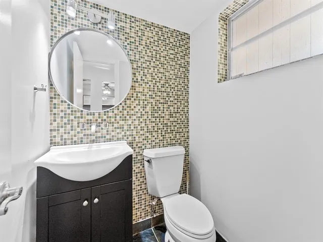 a bathroom with a sink a toilet and mirror