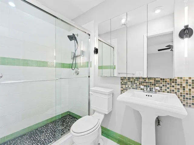 a bathroom with a sink a toilet and shower