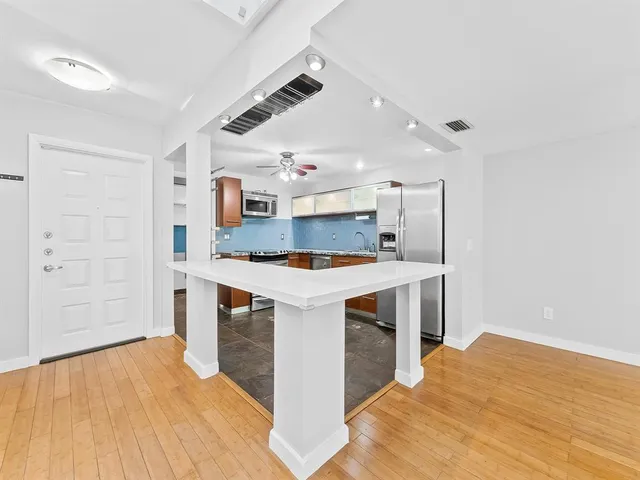 a kitchen with stainless steel appliances kitchen island hardwood floor sink and stove