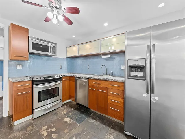 a kitchen with stainless steel appliances granite countertop a stove and a refrigerator
