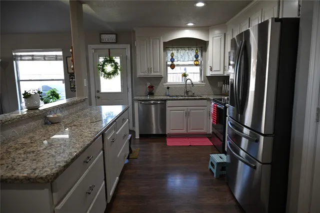 a large kitchen with stainless steel appliances granite countertop a refrigerator and stove