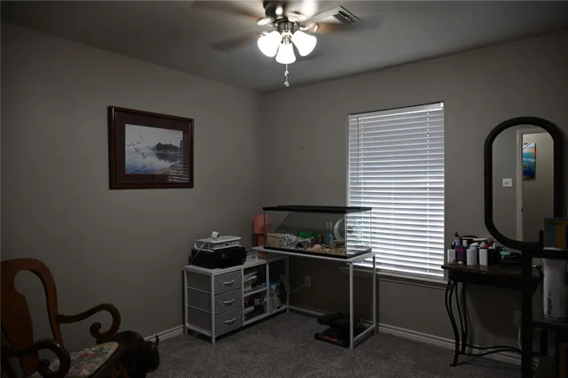 a view of a workspace with furniture and a window