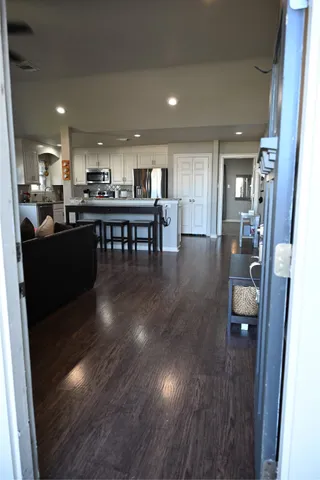 a living room with furniture and a dining table with wooden floor