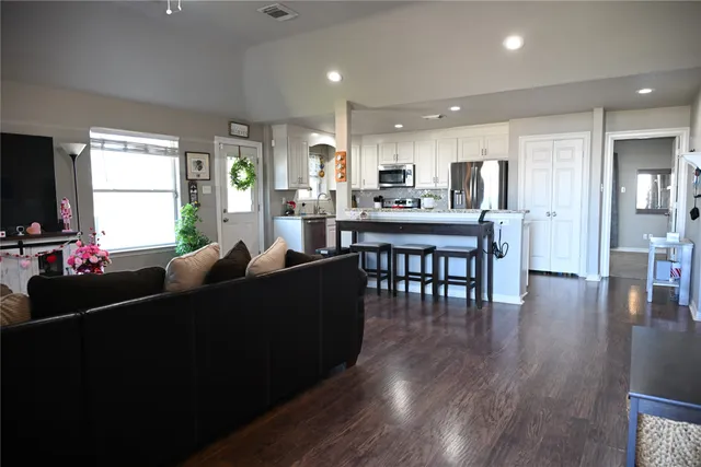 a living room with furniture wooden floor and a flat screen tv