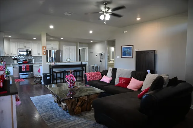 a living room with lots of furniture and kitchen view