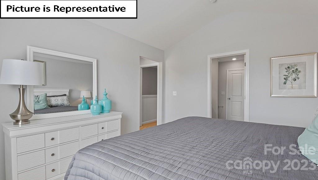 9027 Lowfalls Lane Charlotte, NC 28216 - Photo 17 of 27 a bedroom with a bed and a lamp on dresser