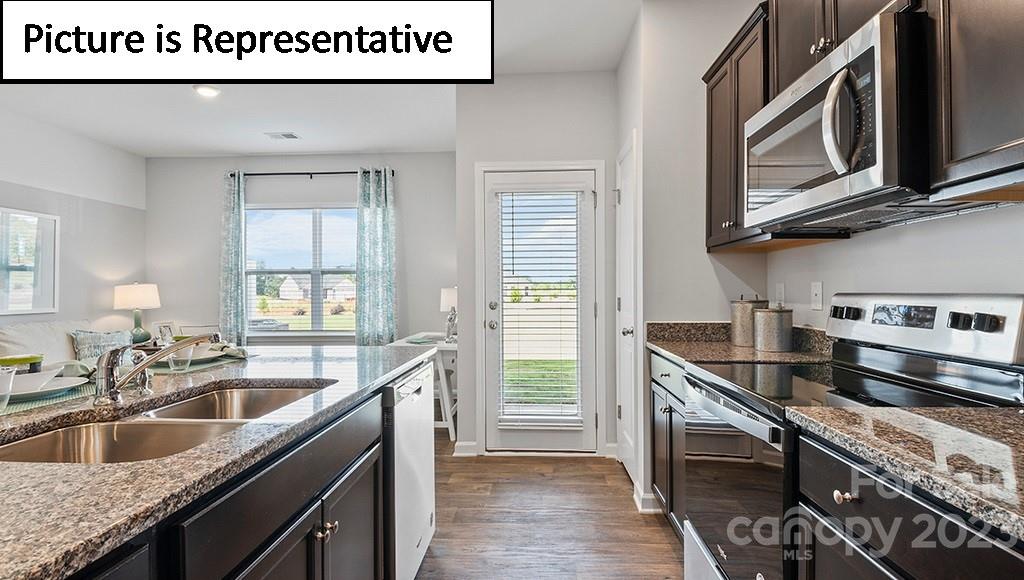 9027 Lowfalls Lane Charlotte, NC 28216 - Photo 10 of 27 a kitchen with stainless steel appliances granite countertop a sink a stove and a wooden cabinets