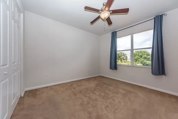 an empty room with a window and a fan