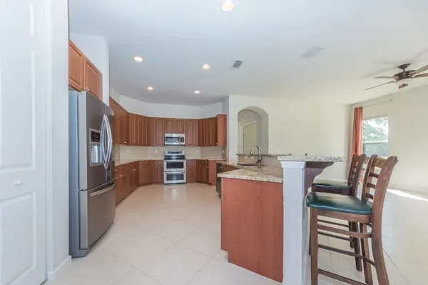 a kitchen with stainless steel appliances granite countertop a sink stove and refrigerator
