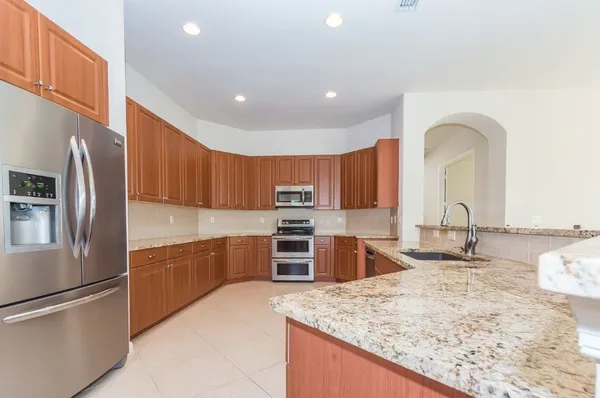 a kitchen with stainless steel appliances granite countertop a stove a microwave oven and a sink with cabinets