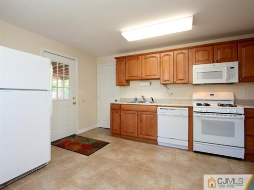 121 New Market Road Dunellen, NJ 08812 - Photo 19 of 23 a kitchen with stainless steel appliances granite countertop a stove a sink and a refrigerator