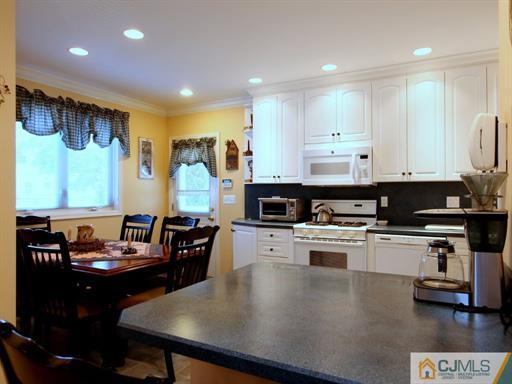 121 New Market Road Dunellen, NJ 08812 - Photo 9 of 23 a kitchen with stainless steel appliances granite countertop a stove a refrigerator a sink a stove and white cabinets with wooden floor