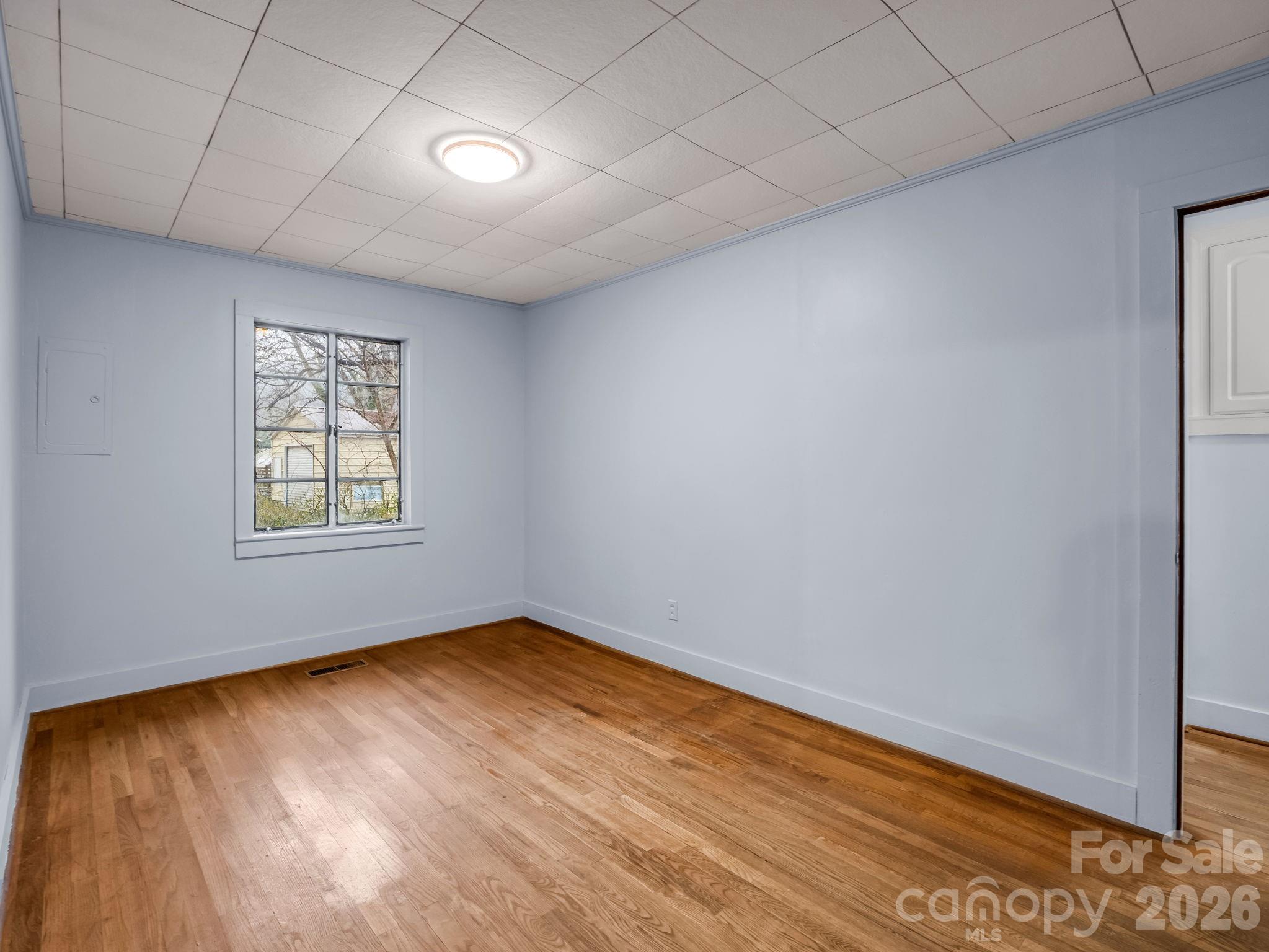 109 Wall Road Tryon, NC 28782 - Photo 14 of 30 an empty room with wooden floor and windows
