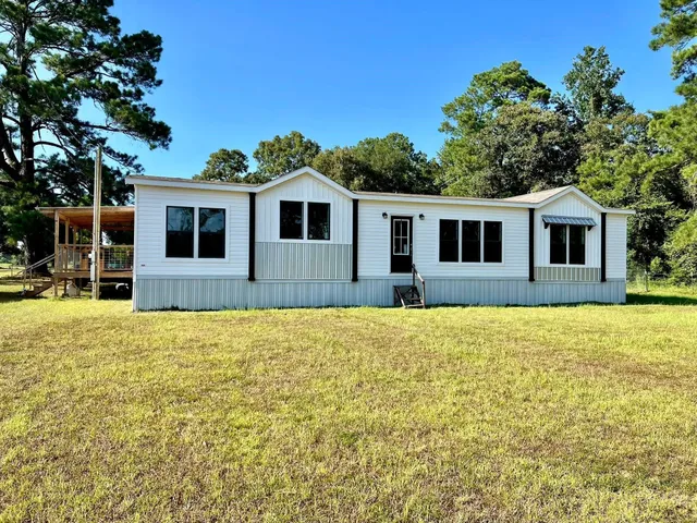 a front view of a house with yard and trees