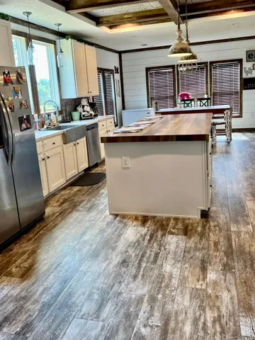 a kitchen with appliances cabinets and a wooden floor