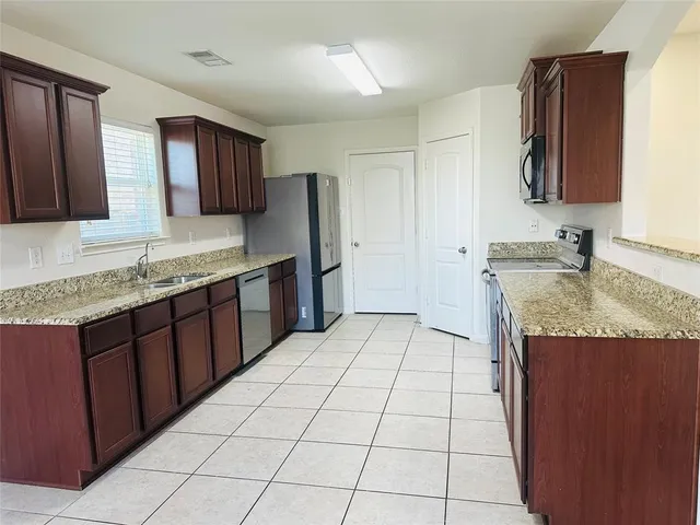 a kitchen with stainless steel appliances granite countertop a sink and cabinets