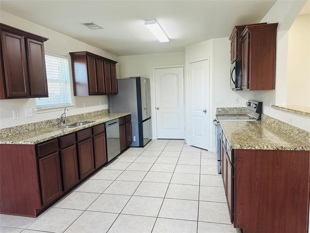 1314 Tamarack Drive Princeton, TX 75407 - Photo 6 of 12 a kitchen with stainless steel appliances granite countertop a sink and cabinets