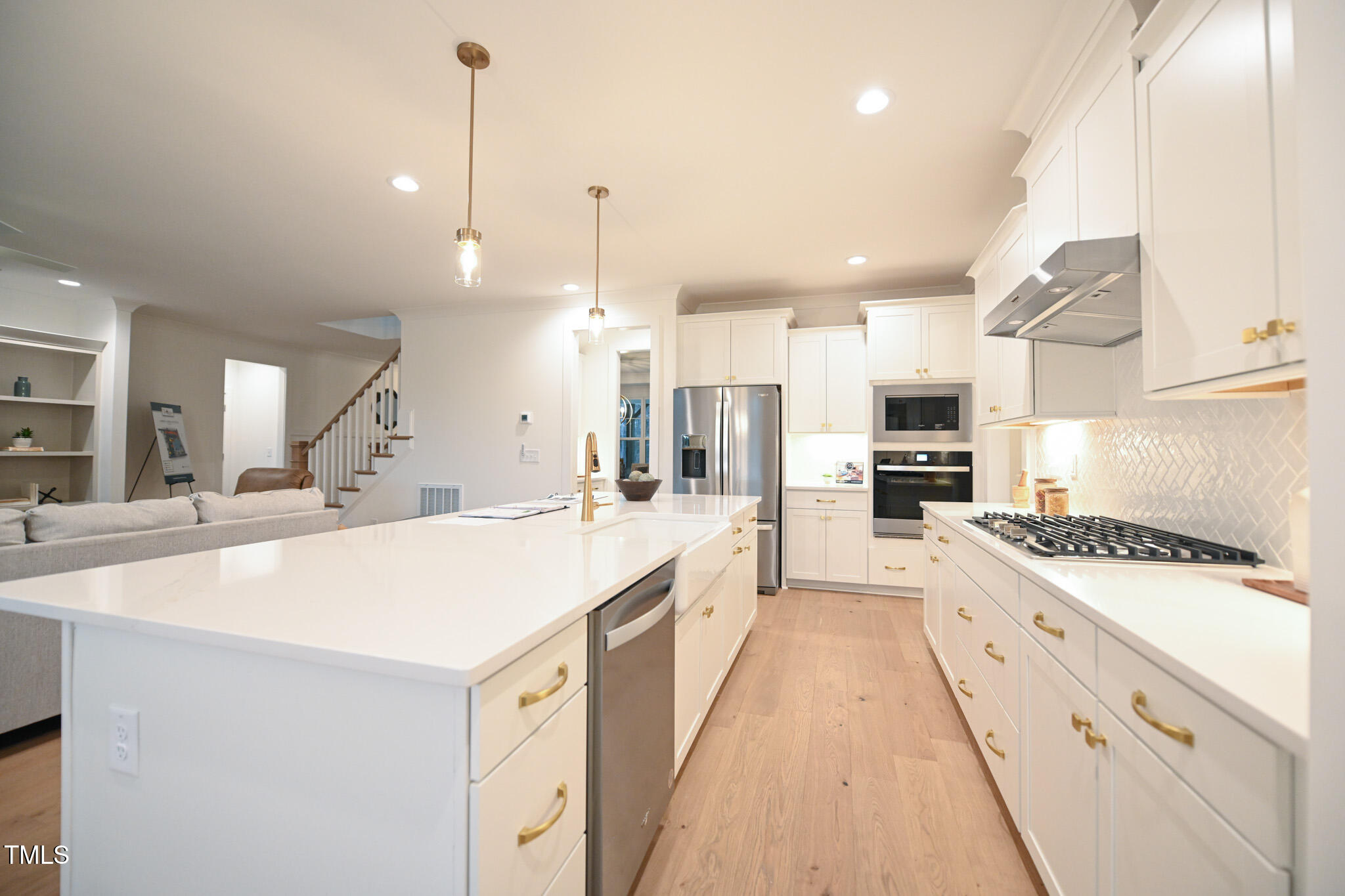 143 Sallyport Court Raleigh, NC 27603 - Photo 14 of 46 a large kitchen with kitchen island a stove a sink a center island and wooden floor