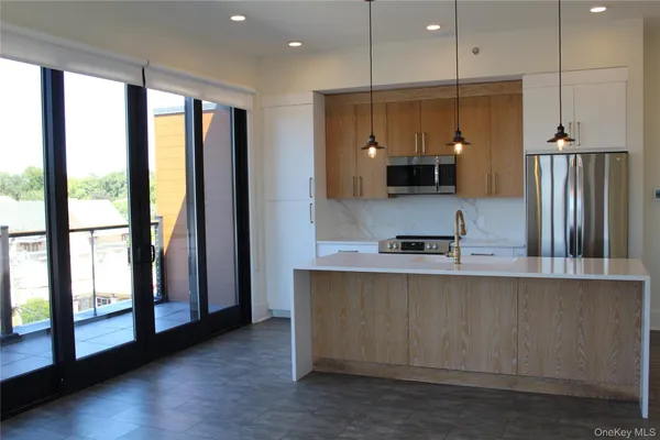 a large kitchen with a large window and stainless steel appliances