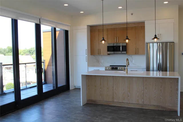 a large kitchen with a large window and stainless steel appliances