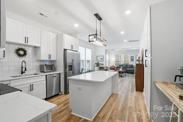 a large kitchen with stainless steel appliances lots of counter space and windows