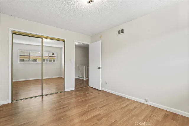 an empty room with wooden floor and window