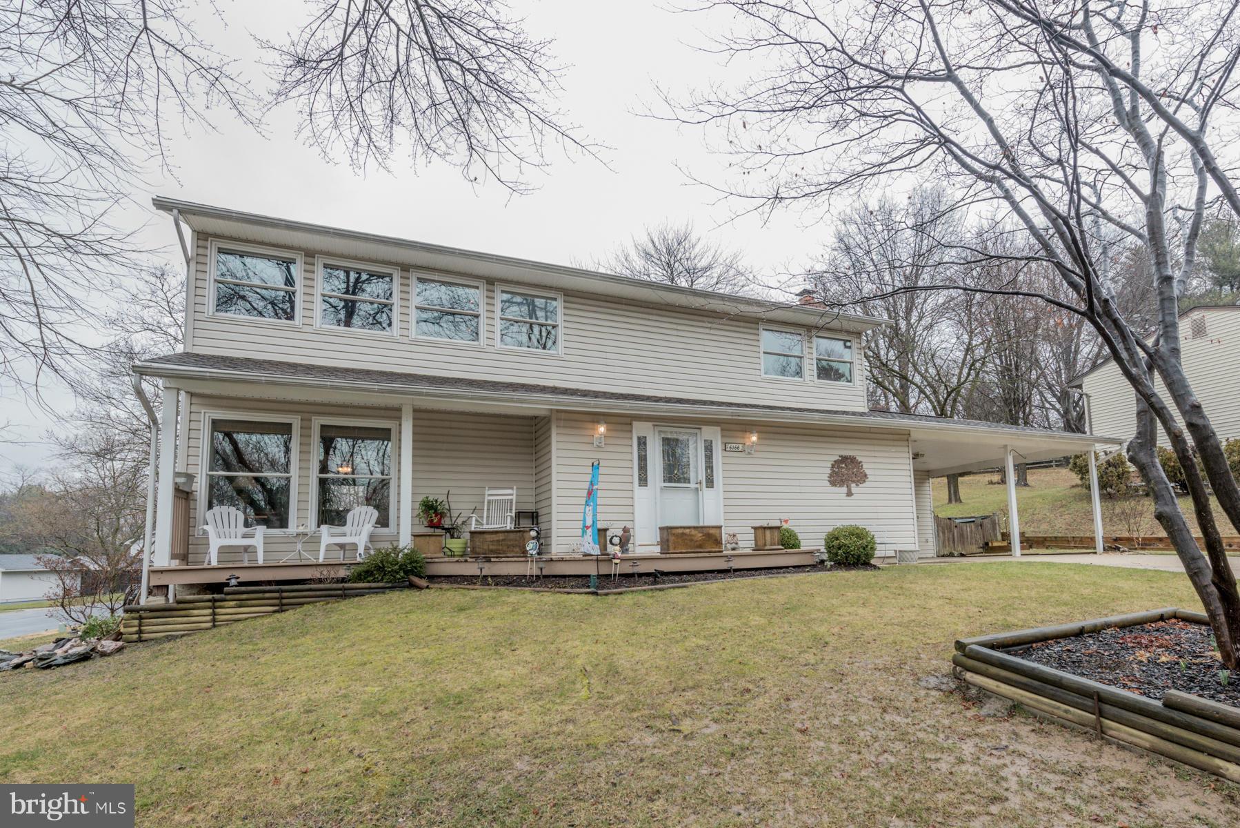 6166 Stevens Forest Road Columbia, MD 21045 - Photo 1 of 28 a front view of a house with lots of trees and plants