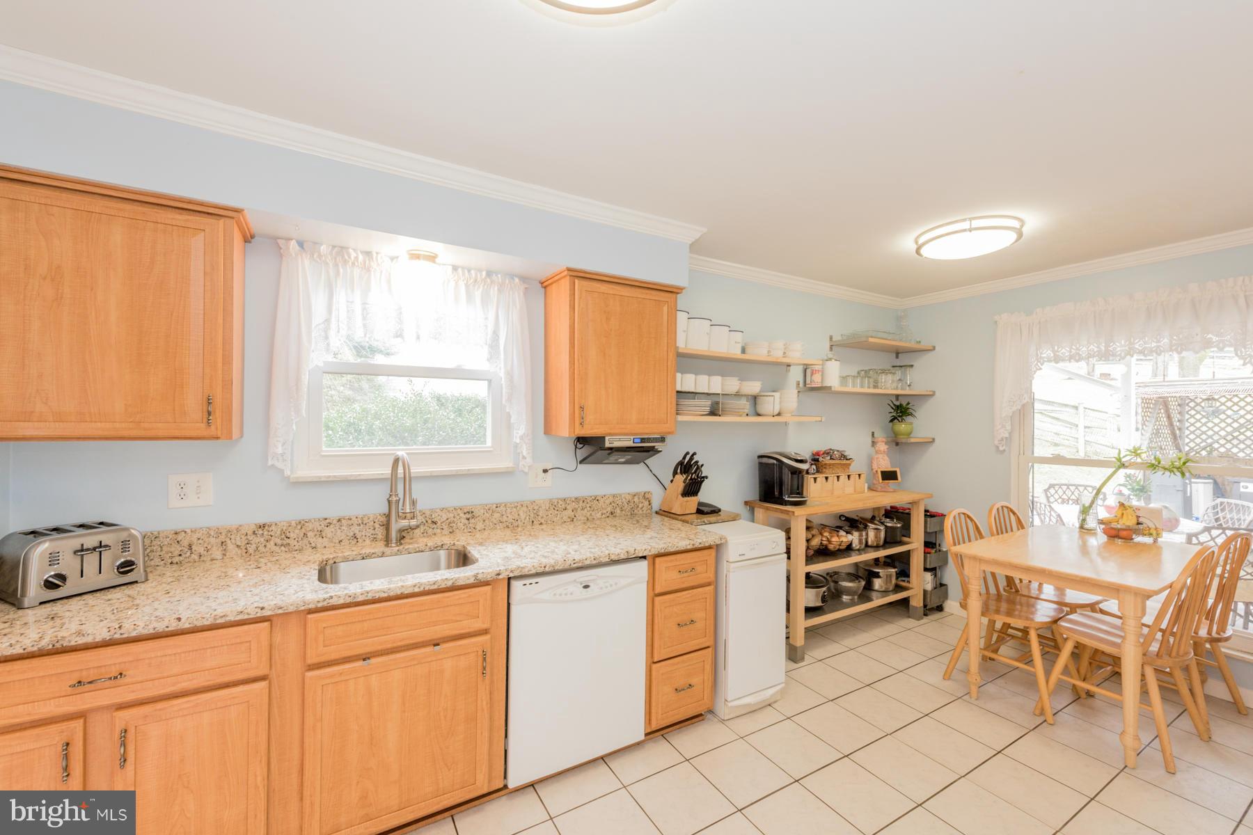 6166 Stevens Forest Road Columbia, MD 21045 - Photo 3 of 28 a kitchen that has a sink and chairs in it