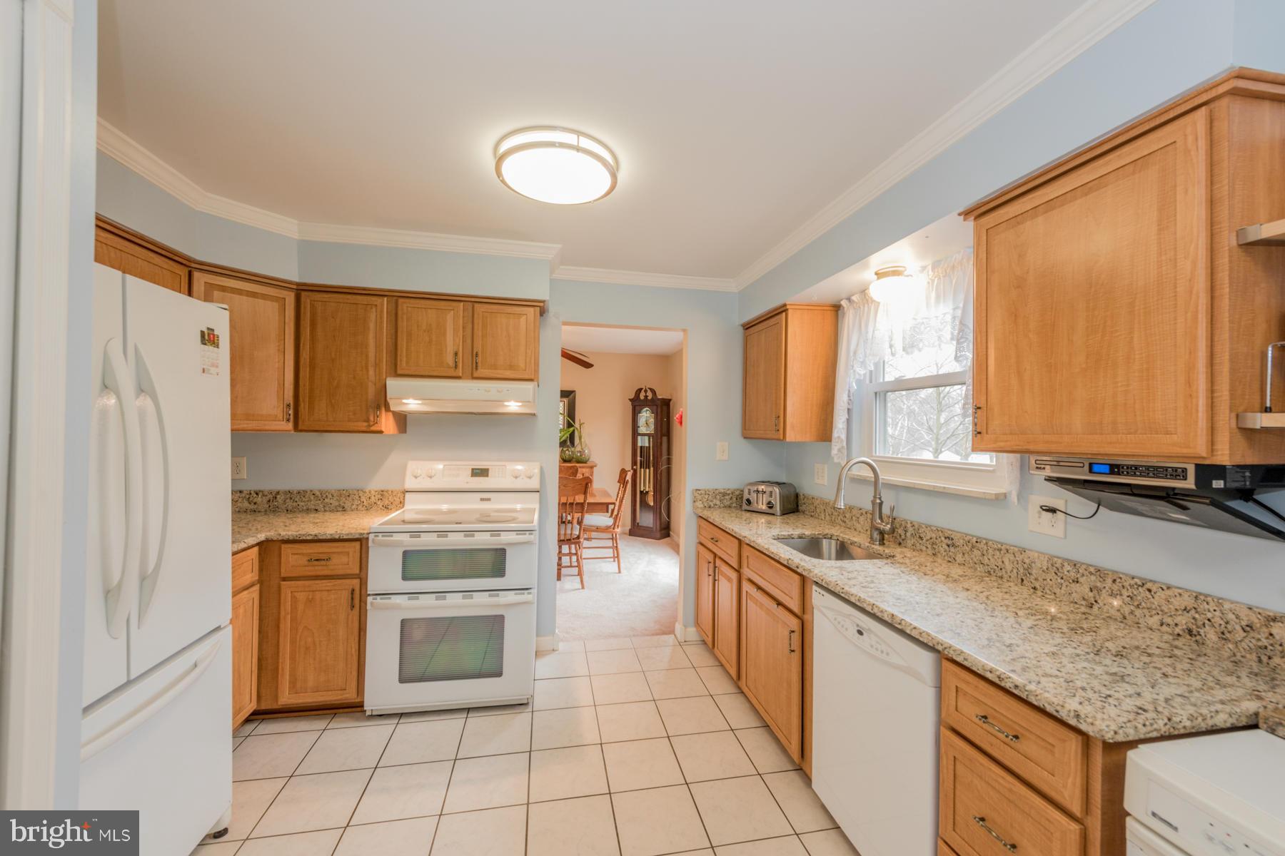 6166 Stevens Forest Road Columbia, MD 21045 - Photo 10 of 28 a kitchen with stainless steel appliances granite countertop a stove a sink and a refrigerator
