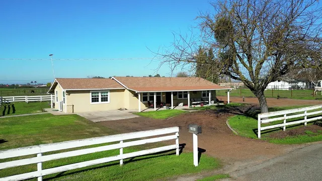 a view of a house with backyard and sitting area