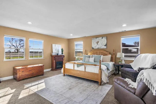 a spacious bedroom with a bed couch and window