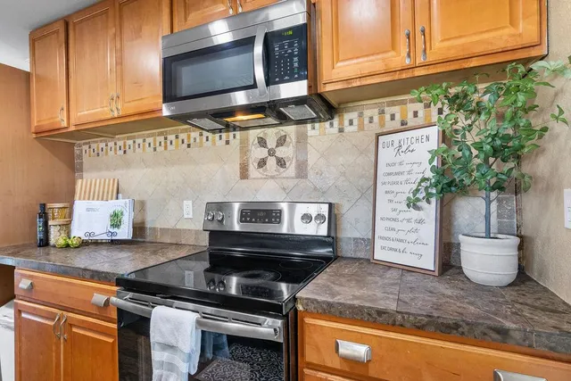 a kitchen with stainless steel appliances granite countertop a sink a stove and cabinets