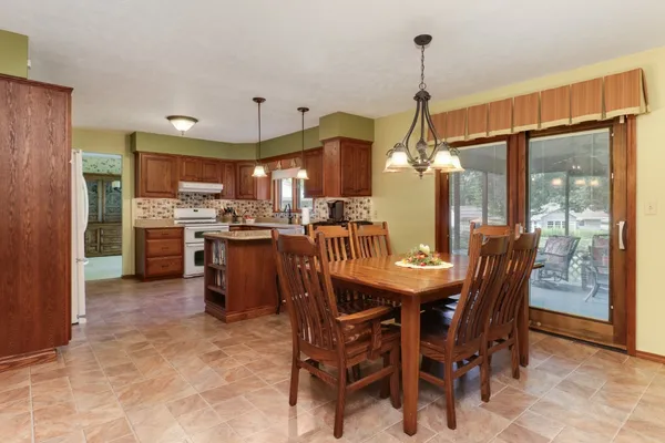a dining room filled with furniture and kitchen view