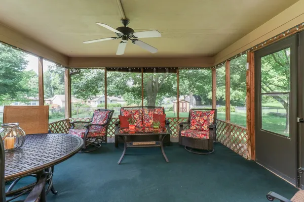 a living room with furniture and floor to ceiling windows