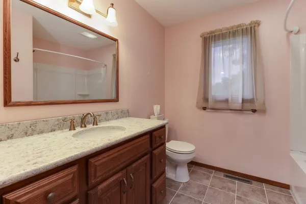 a bedroom with a bed a chair and a chandelier