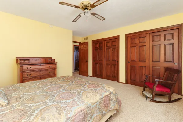 an empty room with closet and ceiling fan