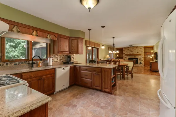 a kitchen with stainless steel appliances granite countertop a sink a stove and a refrigerator
